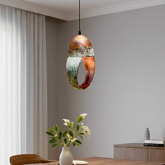 Minimalist bedside lighting with a unique green patina ring pendant on a wooden side table.