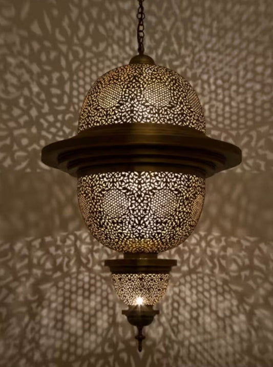 Large handmade Moroccan brass ceiling lamp casting intricate shadow patterns.