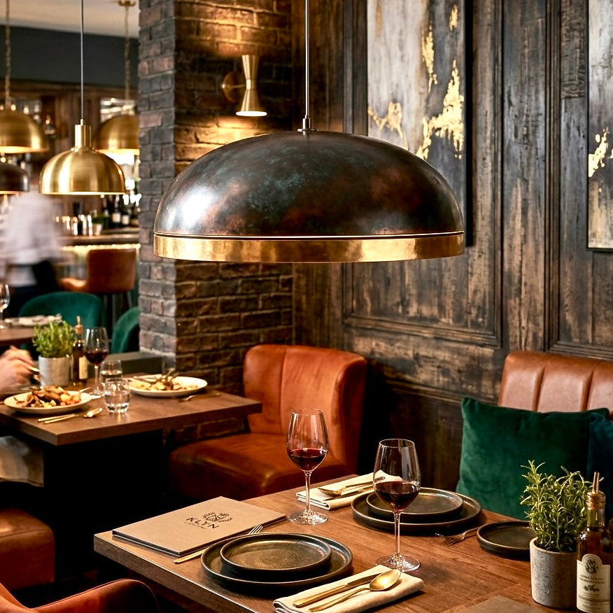 Modern handmade brass dome lamps providing warm ambient lighting in a high-end restaurant dining room.
