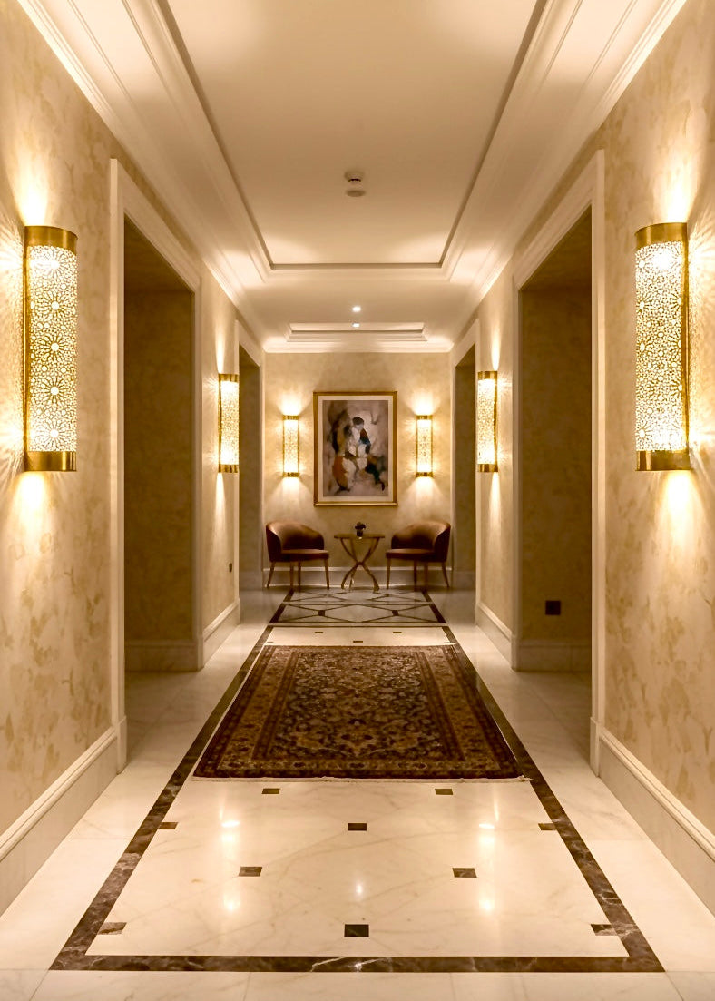 Pair of Moroccan brass wall sconces providing warm ambient lighting.