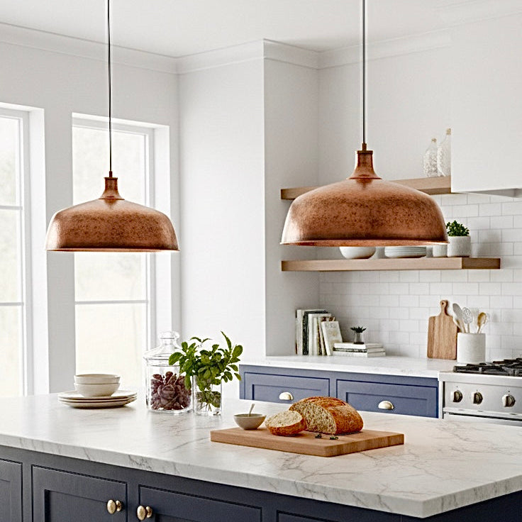 Rustic kitchen interior featuring handmade copper pendant lights and exposed wooden ceiling beams.