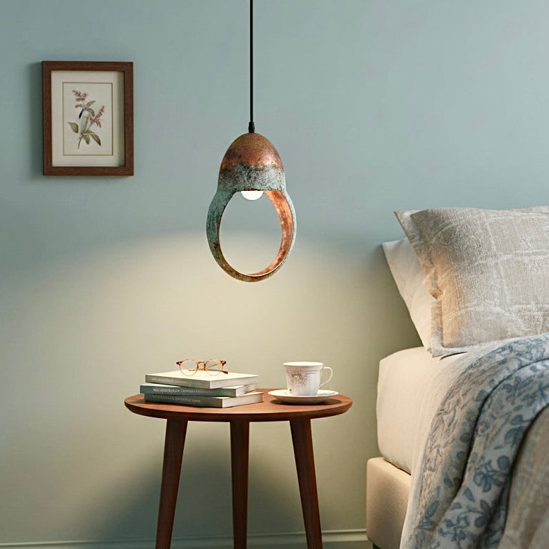 Verdigris copper loop lamp hanging in a modern living room for a rustic-luxe feel