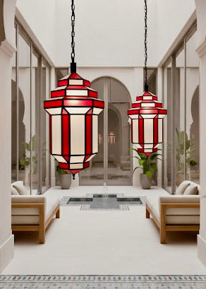Large Moroccan brass lanterns hanging in a modern white Riad courtyard, premium hospitality lighting for hotels.