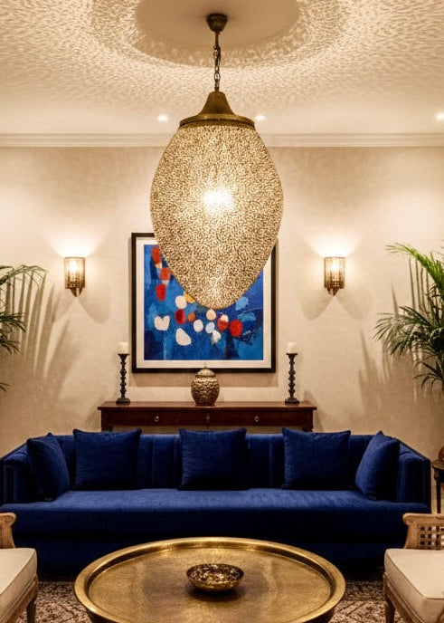 Luxurious Moroccan brass pendant light hanging over a dining table in a modern Moroccan styled dining room.