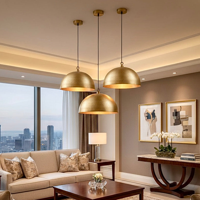 Set of three hammered brass pendant lights in a modern luxury living room setting.
