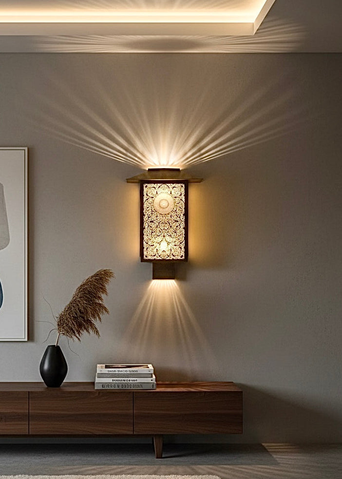 Single Moroccan brass wall lamp creating stunning shadow art in a minimalist modern living room.