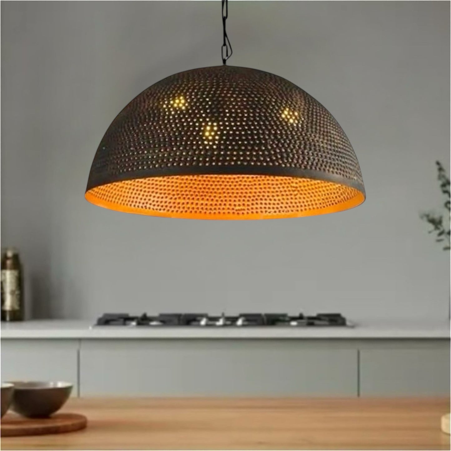 Industrial black dome pendant light with hammered gold interior hanging over a modern kitchen island.