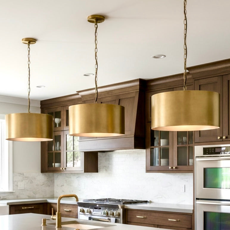 Modern brass drum lighting installation in a luxury hotel lobby or professional office reception area.