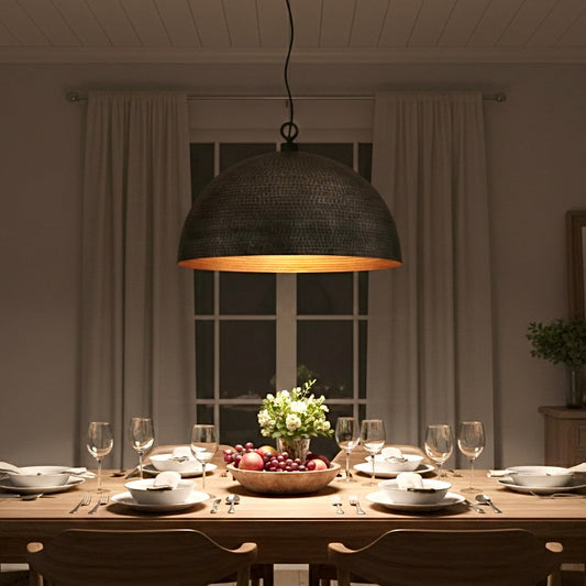 Industrial style black and gold dome pendant light hanging over a wooden dining table in a modern home.