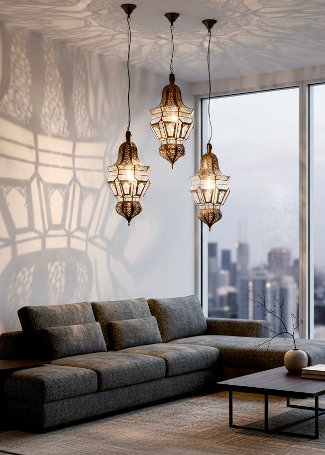 Three Moroccan glass lanterns hanging in a modern living room creating beautiful geometric shadow patterns on the walls.