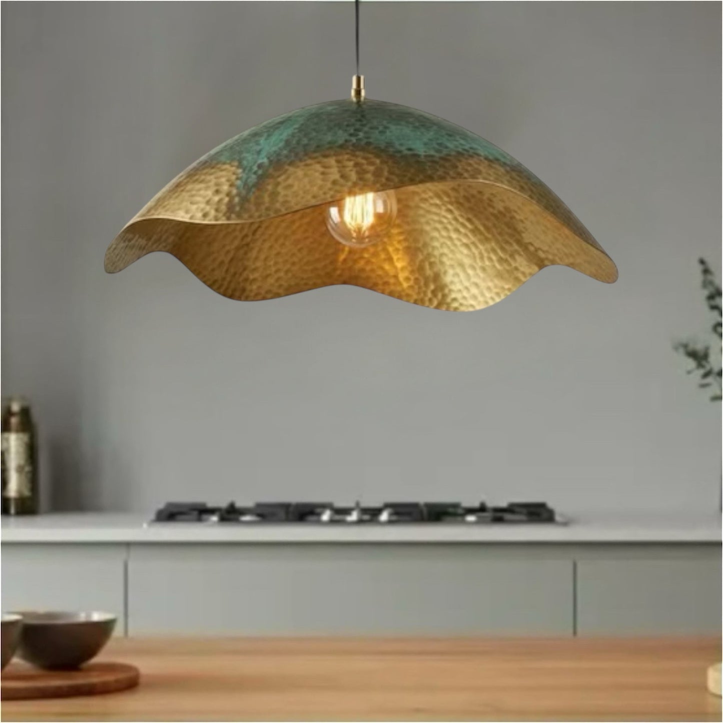 Modern dome brass hammered gold and patina green Moroccan handmade lamp hanging in a living room.