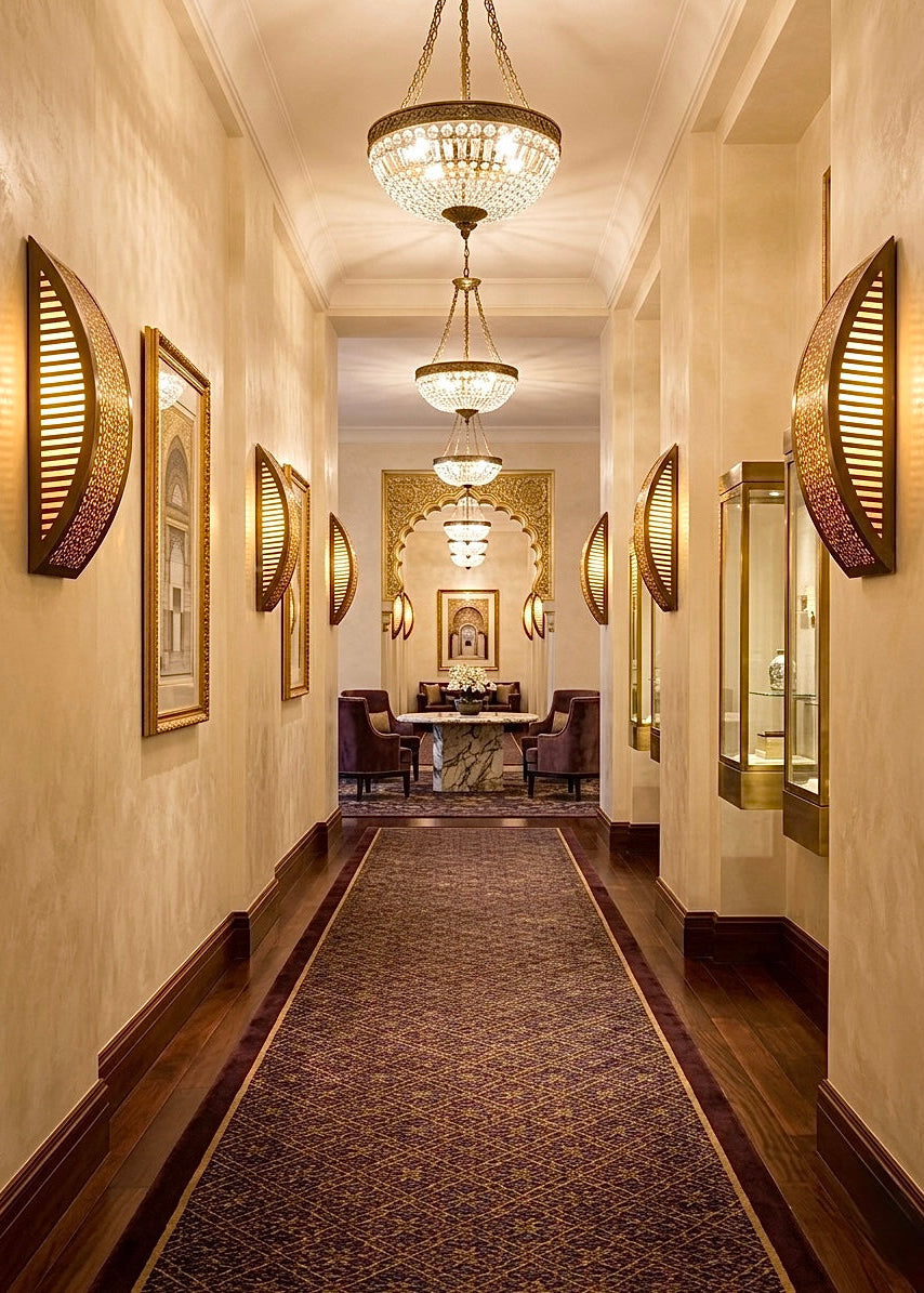 A curved Moroccan brass wall lamp mounted in a minimalist modern interior, providing warm ambient lighting.