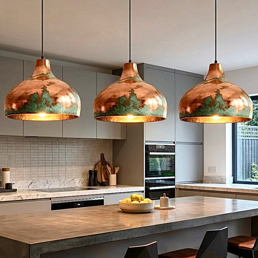 Luxury modern green patina copper dome pendant light over a white kitchen island.
