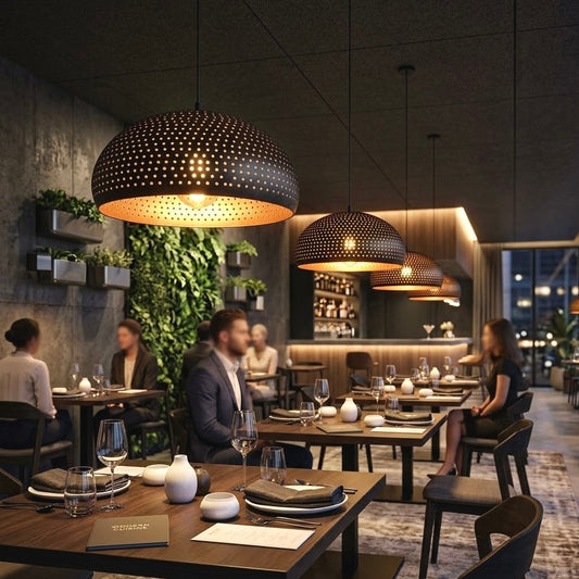 Modern perforated black metal dome lights with glowing gold interiors installed across a stylish restaurant dining room area.
