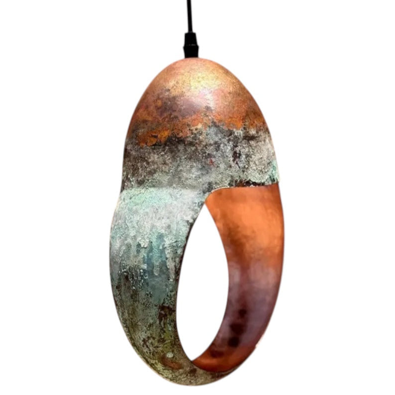 Modern sculptural ring pendant light with green patina exterior and warm red copper interior.