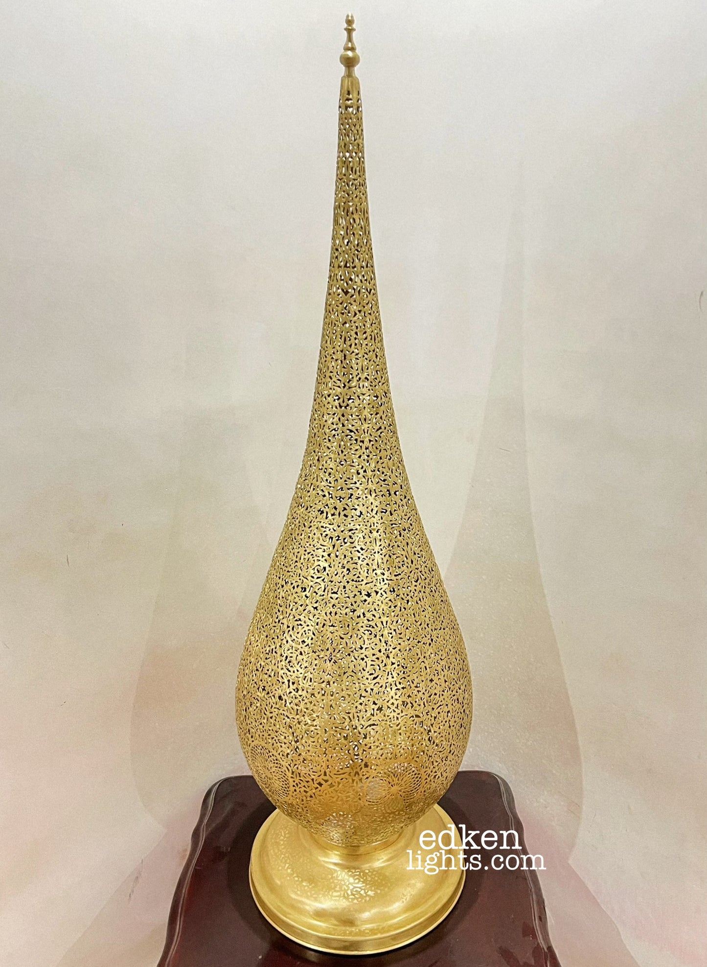 Small Moroccan brass bedside lamp providing ambient light and exotic shadow play.