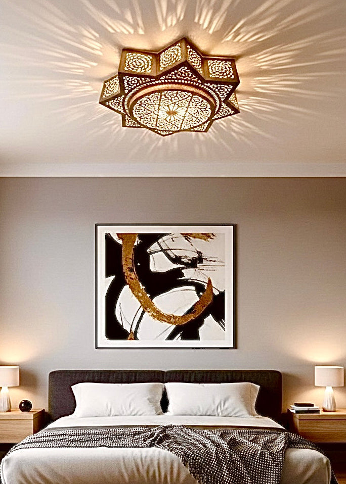 Decorative Moroccan solid brass ceiling light above a bed, creating a warm and cozy atmosphere with intricate hand-carved shadows.
