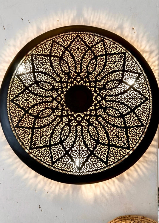 Close-up of the handcrafted geometric pattern on a Moroccan brass lamp, showcasing the high-quality craftsmanship and shadow effects.