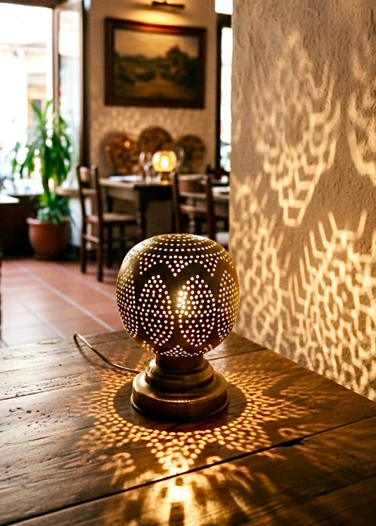 Small Moroccan brass lanterns used as centerpieces for cafe tables, creating a romantic and warm dining atmosphere.