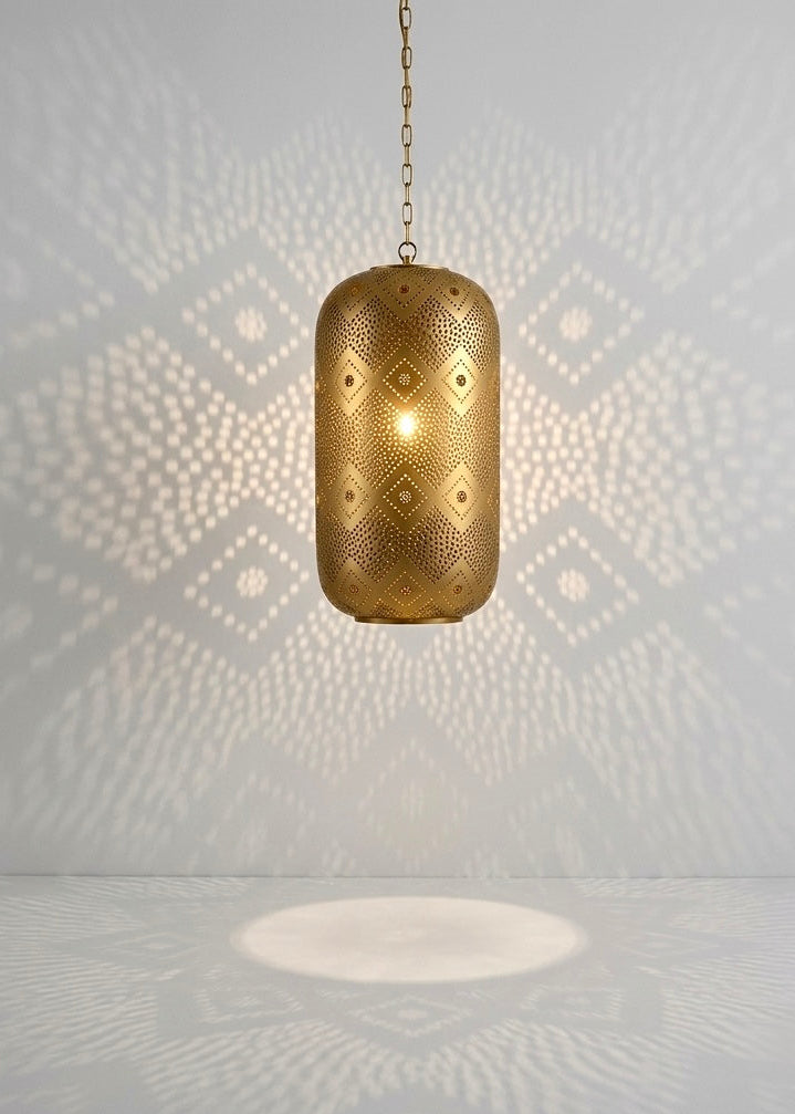Handcrafted Moroccan brass pendant light hanging in a minimalist room, casting intricate geometric shadow patterns on the wall and floor.⁠