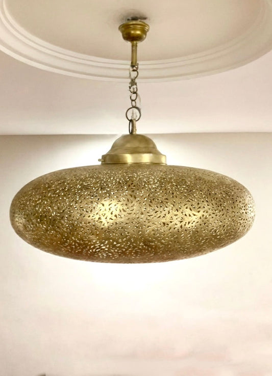 Large Moroccan chandelier hanging in a modern living room, casting warm exotic light and traditional shadow designs.