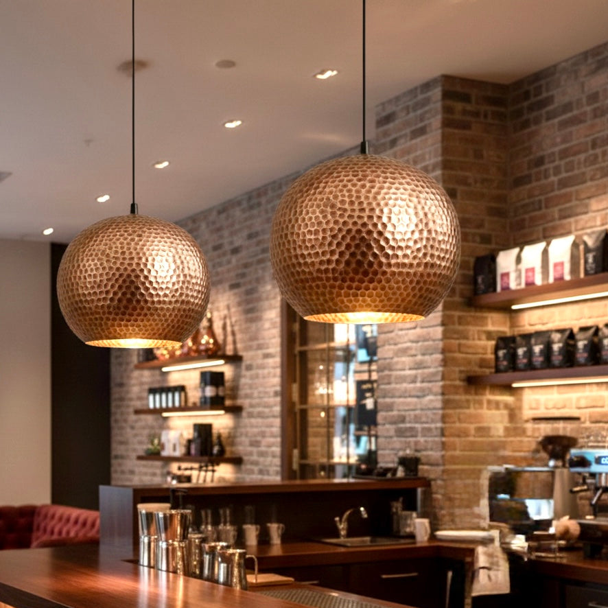 Moroccan handmade hammered copper dome lamps lighting a modern cafe bar counter.