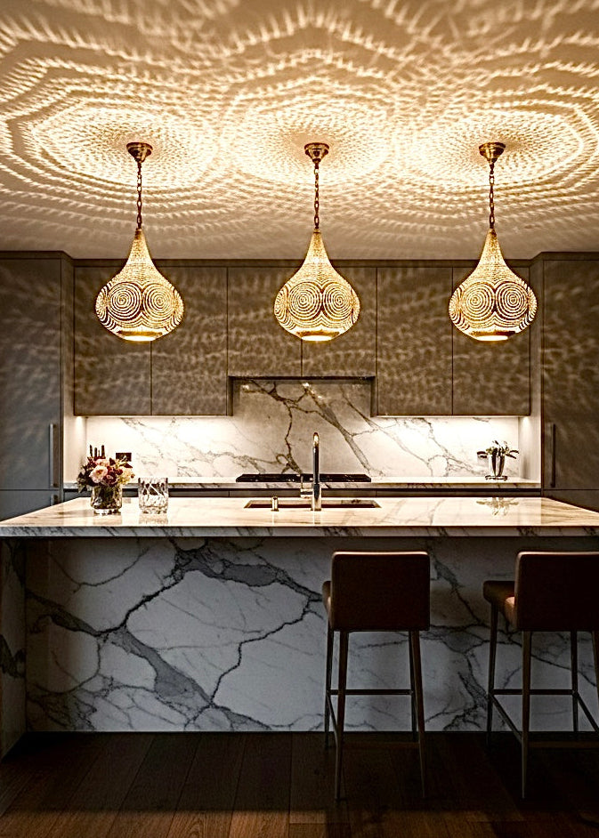 Mesmerizing geometric shadow patterns projected on a wall by a Moroccan pendant light, creating a bohemian atmosphere.