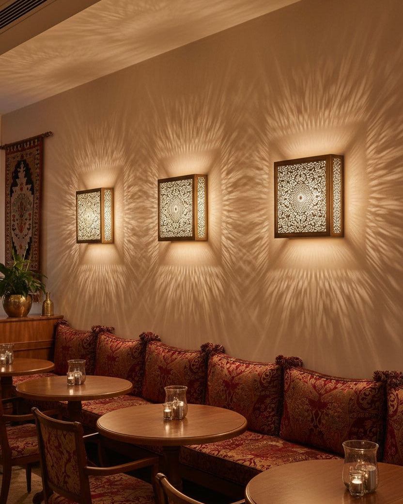 Oriental style decorative wall light emitting a warm golden glow through ornate brass carvings.