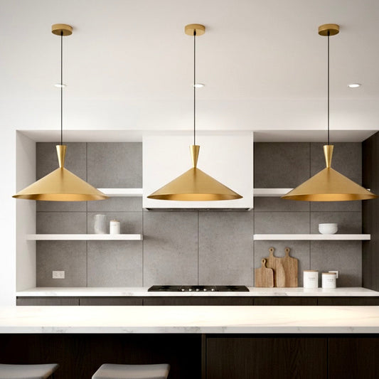 Three modern gold cone ceiling lights installed in a row over a white marble kitchen island with dark cabinetry.