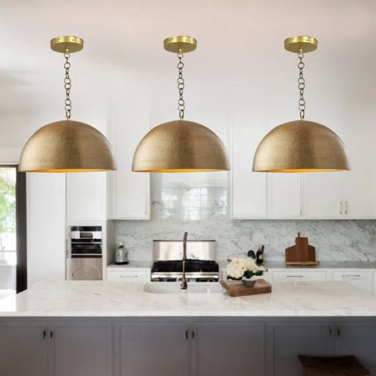Set of 3 modern hammered brass dome pendant lights for kitchen island decor.