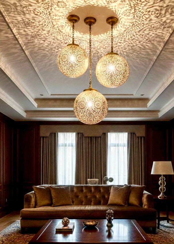 Luxury dining area with a chandelier set of three handmade Moroccan sphere lamps in gold and brass.