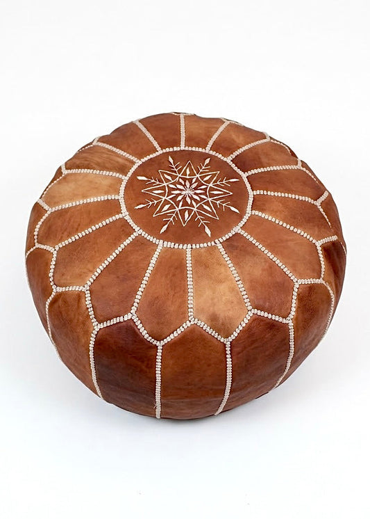 Handmade tan brown Moroccan leather pouf with authentic white stitching embroidery isolated on white background⁠