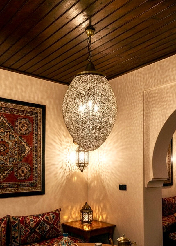 Traditional Moroccan living room with handmade brass pendant light, Persian rug, and cozy seating area.