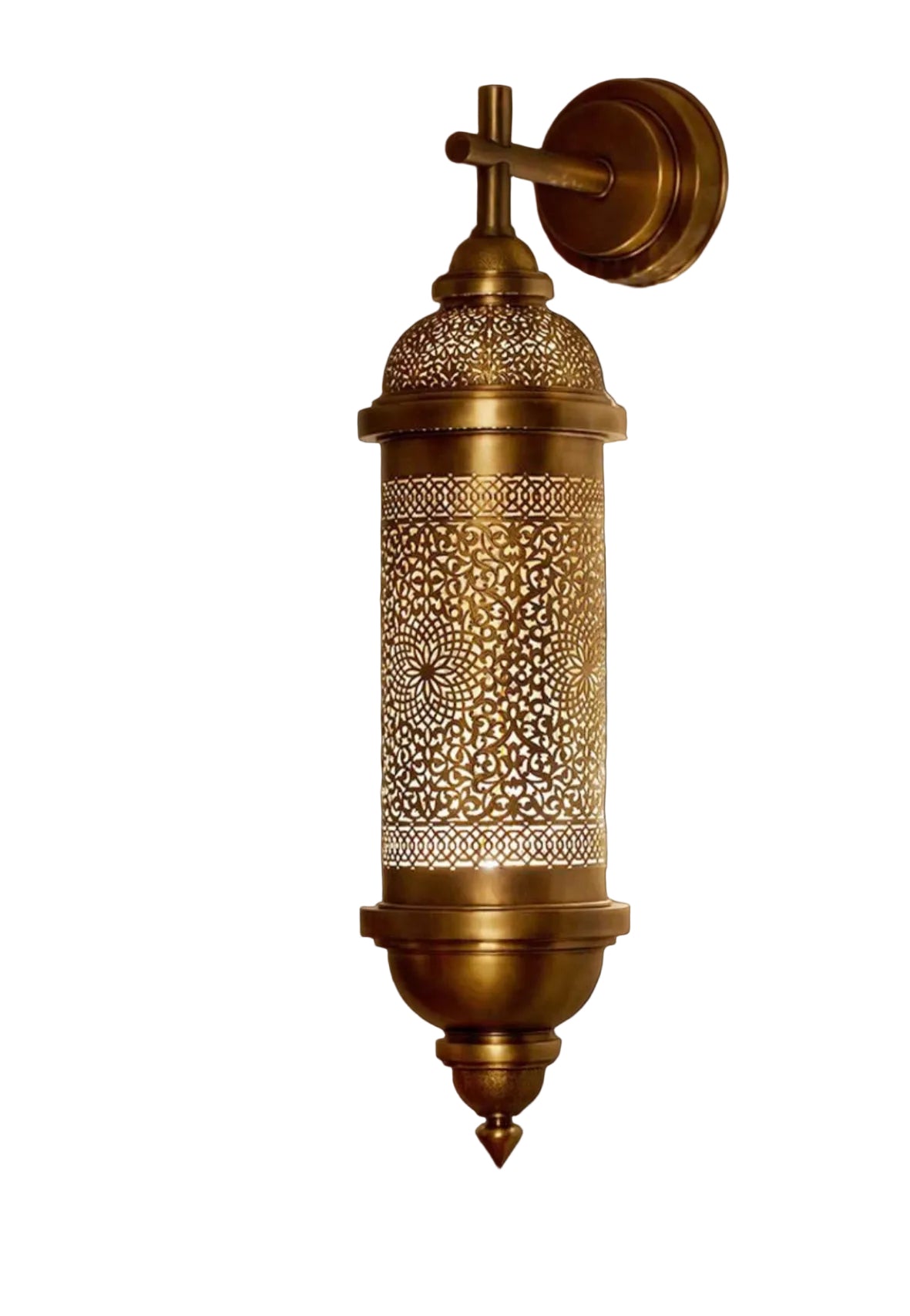 Traditional handcrafted brass sconce casting decorative patterns on wall.