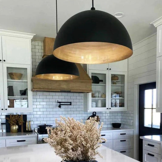 Trio of black and gold hanging lamps perfectly spaced over a contemporary kitchen island.