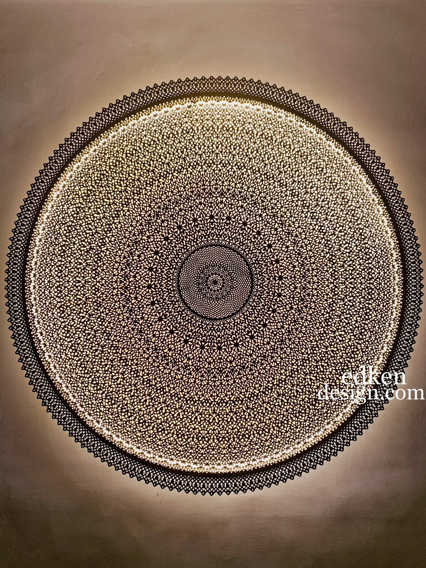 Detailed close-up of a handcrafted etched brass wall sconce, traditional Moroccan craftsmanship with sunburst light pattern, Edken lights.