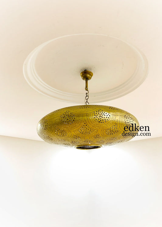 Intricate floral shadow patterns on a ceiling created by a handcrafted Moroccan brass lamp.