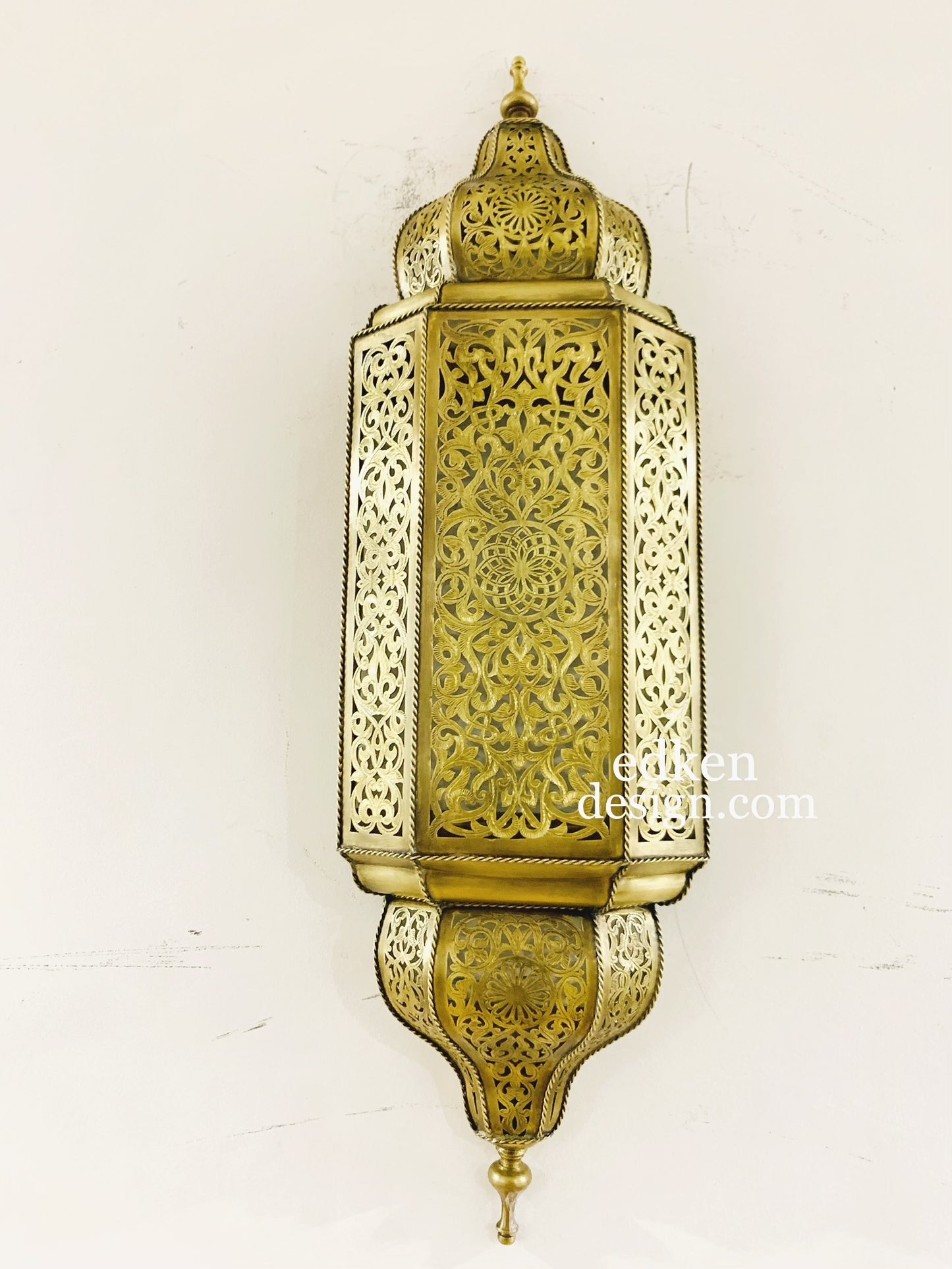 Authentic Moroccan brass sconce with detailed hand-engravings, projecting beautiful shadow play on the wall.